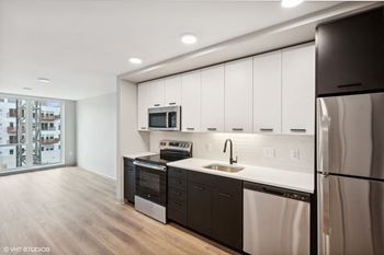 a kitchen with white cabinets and stainless steel appliances and a refrigerator